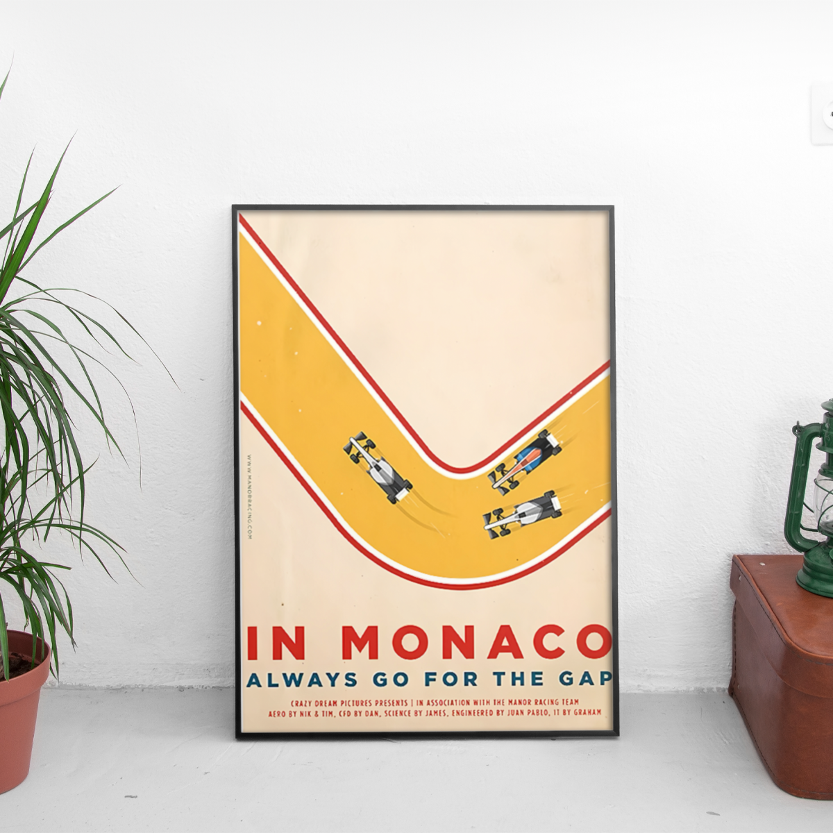 Framed poster of a race track with cars and text 'In Monaco Always Go for the Gap'.