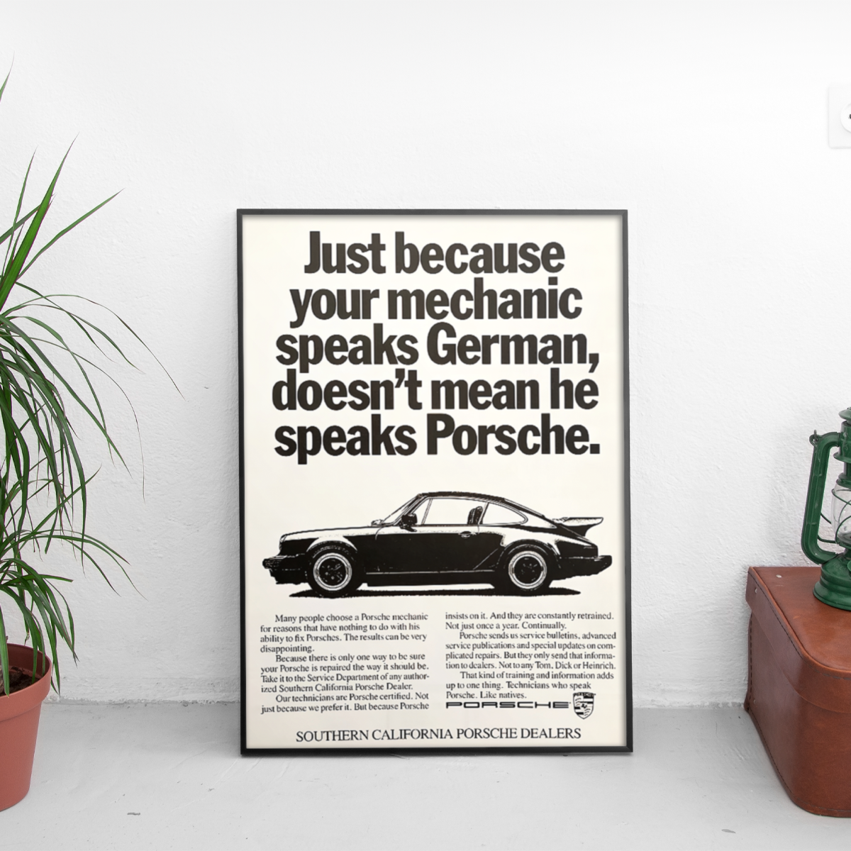 Framed poster with Porsche advertisement on a white wall.